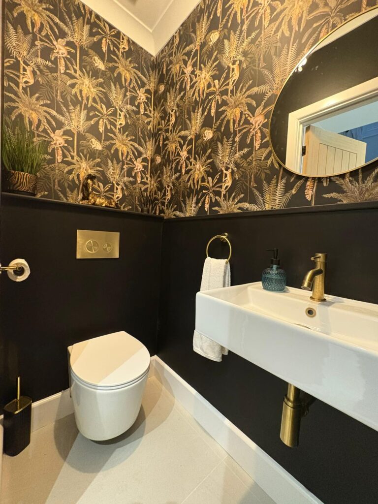 Low-down shot of a white sink, toilet floor and a circular mirror.